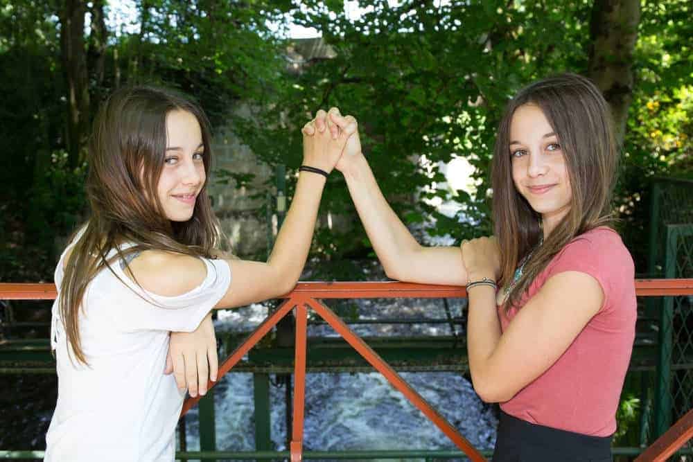 teenage sisters holding hands